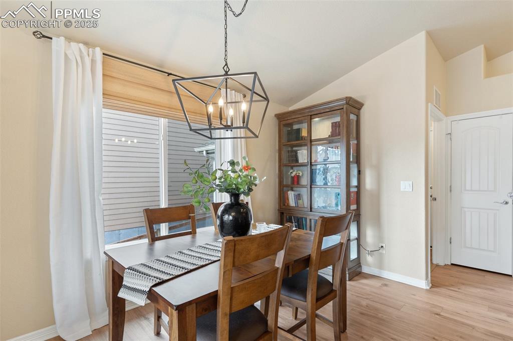 977 Salmon Pond Way Colorado Springs, CO 80921 - Photo 24 of 49 a dining room with furniture potted plants and wooden floor