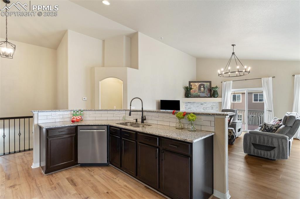 977 Salmon Pond Way Colorado Springs, CO 80921 - Photo 26 of 49 a kitchen with stainless steel appliances granite countertop a sink and dishwasher with wooden floor