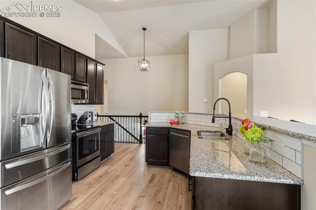 977 Salmon Pond Way Colorado Springs, CO 80921 - Photo 27 of 49 a kitchen with kitchen island granite countertop a sink stainless steel appliances and cabinets