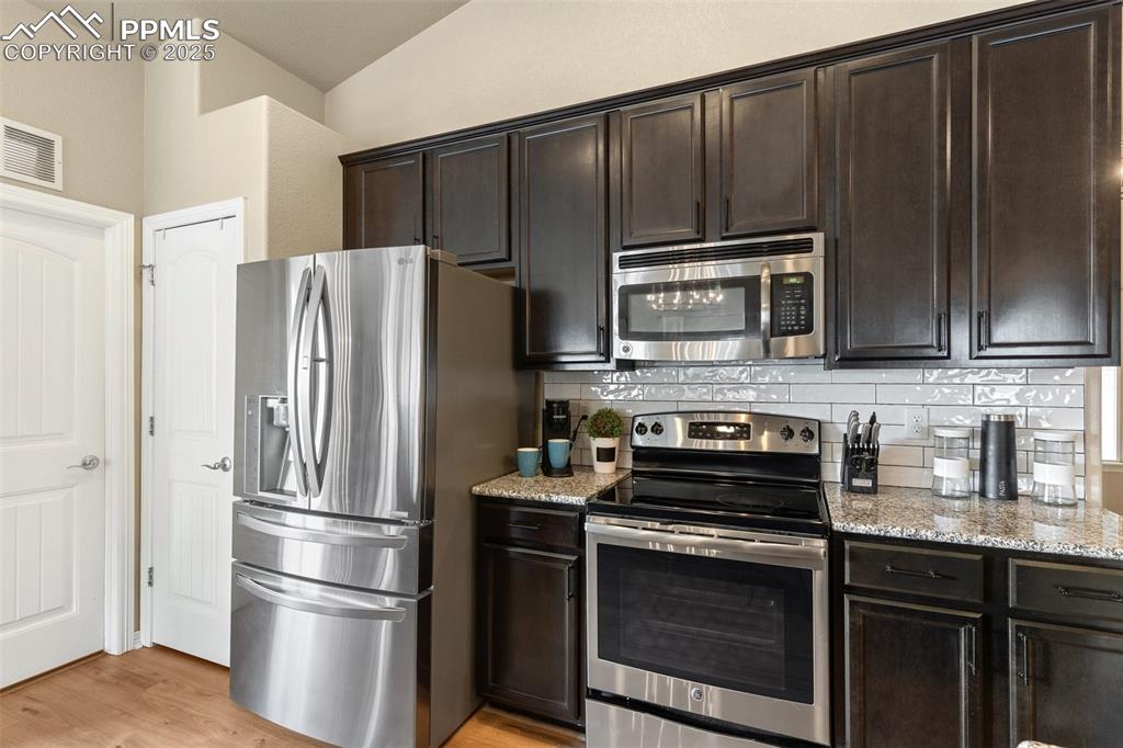 977 Salmon Pond Way Colorado Springs, CO 80921 - Photo 28 of 49 a kitchen with granite countertop stainless steel appliances and wooden cabinets