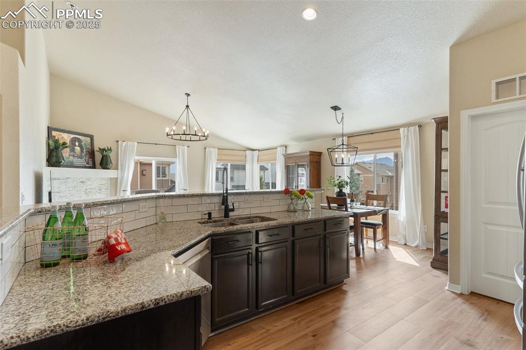 977 Salmon Pond Way Colorado Springs, CO 80921 - Photo 29 of 49 a kitchen with stainless steel appliances granite countertop a sink and wooden cabinets
