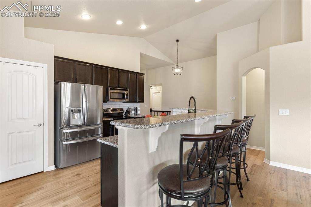 977 Salmon Pond Way Colorado Springs, CO 80921 - Photo 30 of 49 a kitchen with stainless steel appliances a dining table chairs refrigerator and microwave