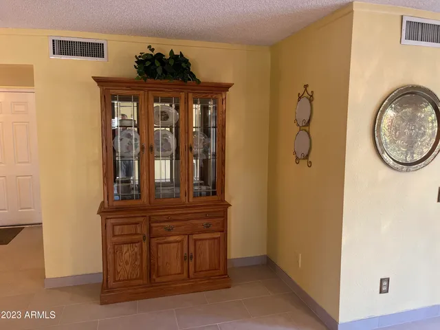 a living room with a couch and a dresser next to a window