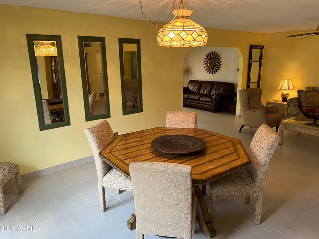 a view of a patio with chairs and table under an umbrella