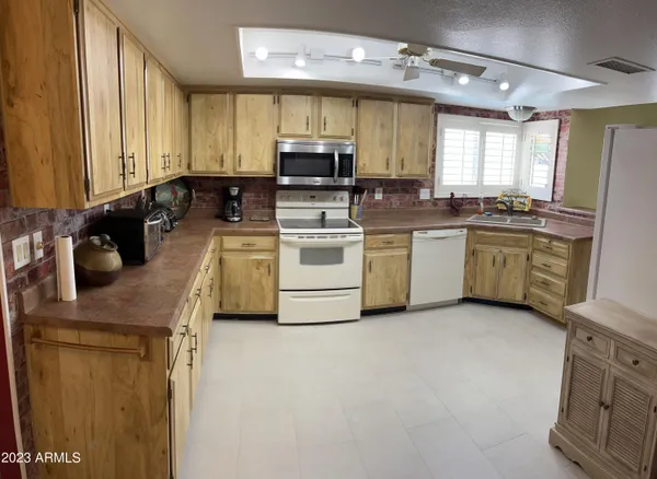 a kitchen with stainless steel appliances granite countertop a sink a stove and a refrigerator