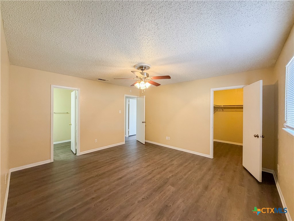 3806 Shallow Ford Road Temple, TX 76502 - Photo 12 of 20 an empty room with wooden floor chandelier fan and windows
