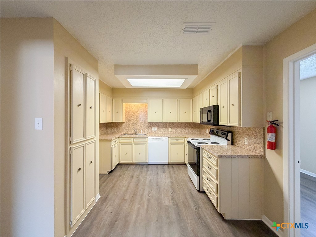 3806 Shallow Ford Road Temple, TX 76502 - Photo 5 of 20 a kitchen with cabinets a sink and wooden floor