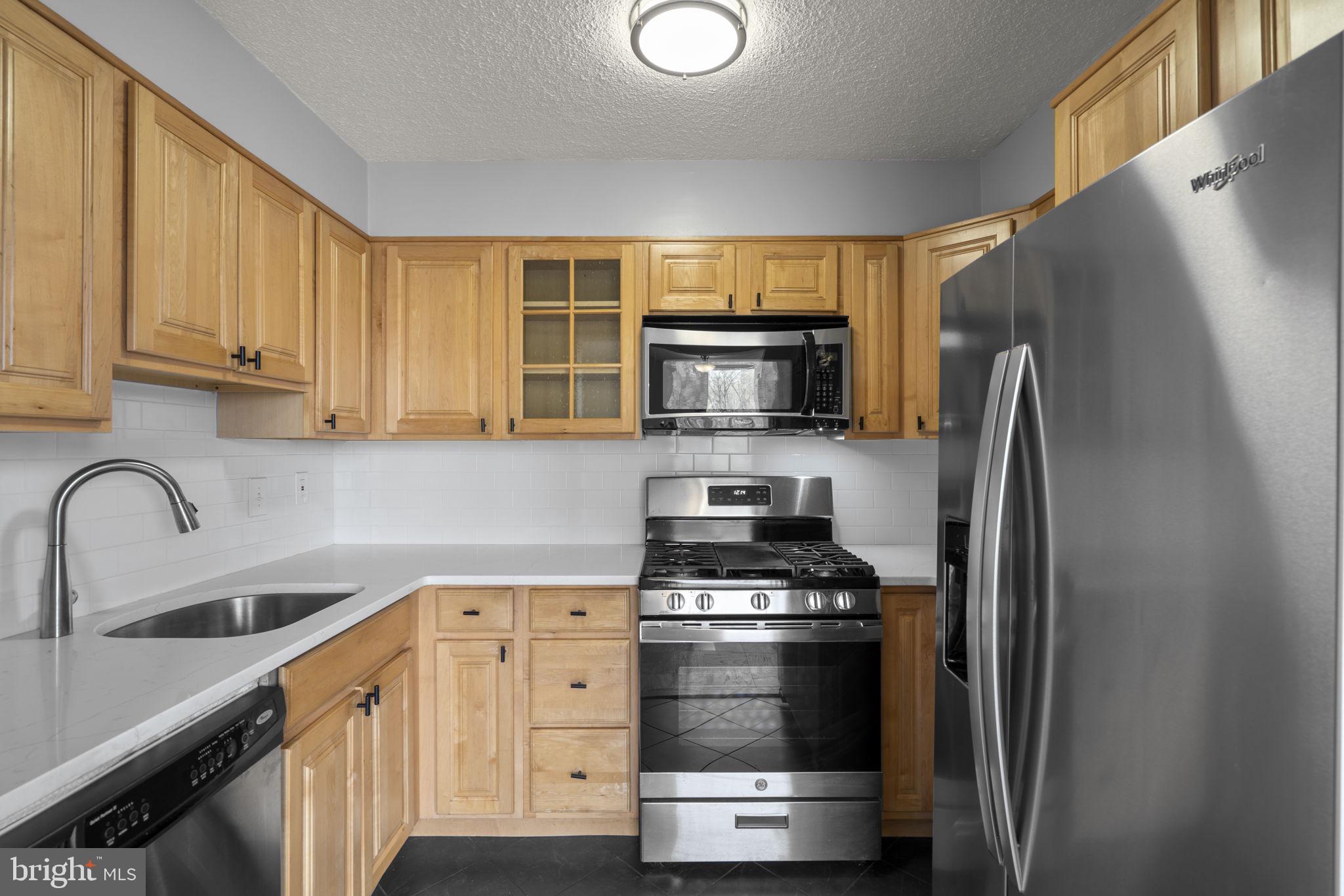 2100 Washington Avenue, Unit 9D Silver Spring, MD 20910 - Photo 19 of 29 a kitchen with appliances a sink and cabinets