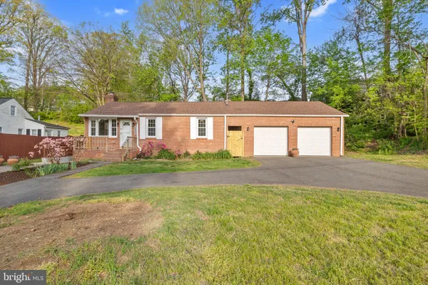 a front view of a house with a garden and trees