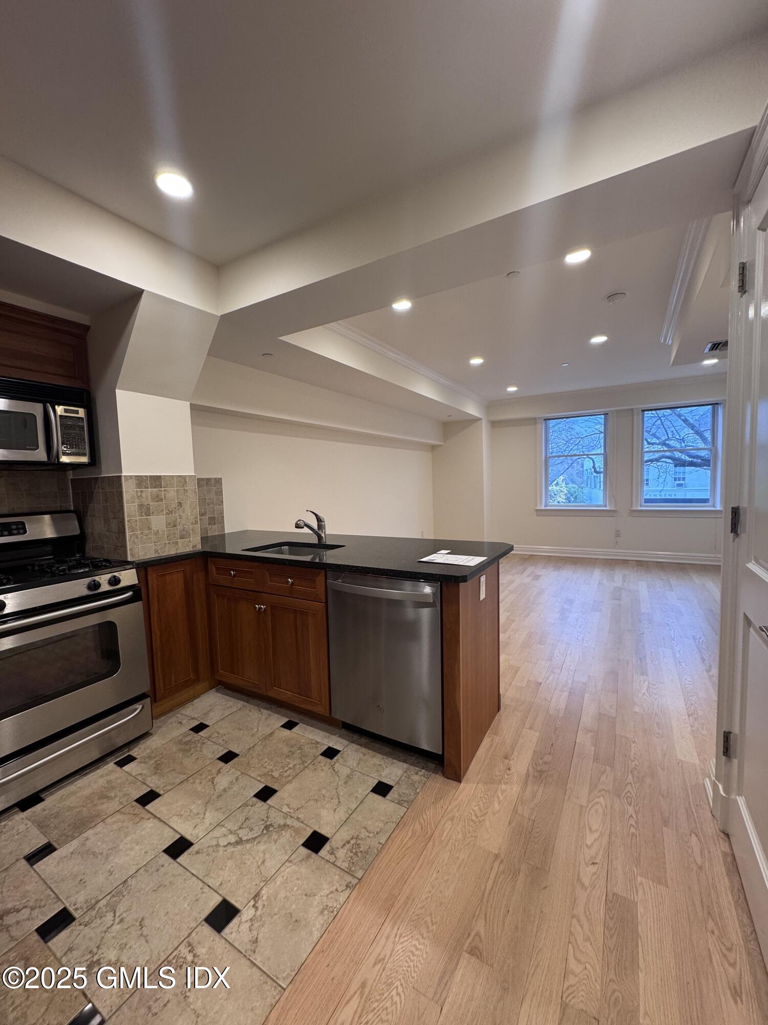 275 Greenwich Avenue, Unit 2B Greenwich, CT 06830 - Photo 2 of 8 a kitchen with stainless steel appliances kitchen island granite countertop a stove a sink and a refrigerator