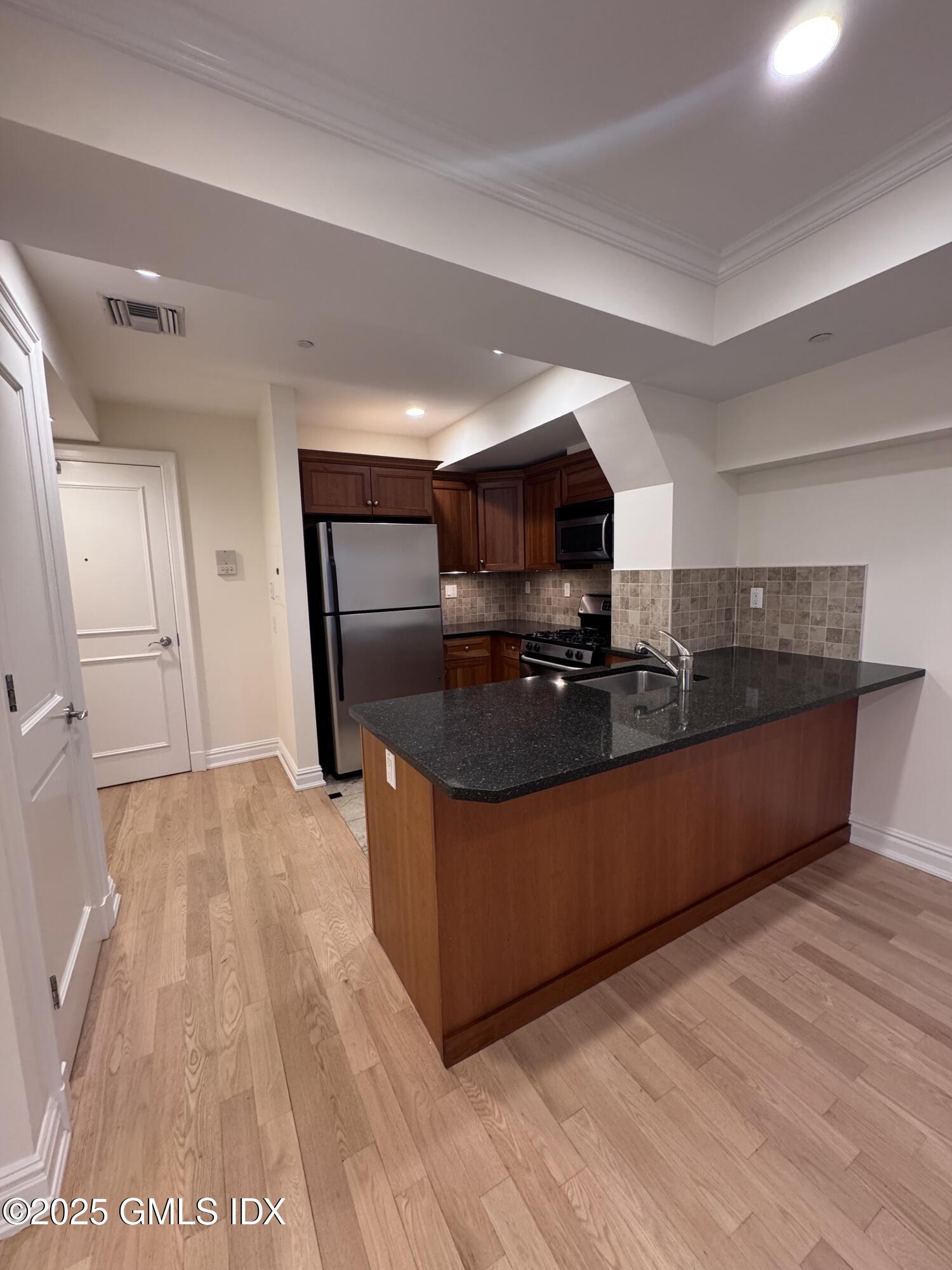 275 Greenwich Avenue, Unit 2B Greenwich, CT 06830 - Photo 3 of 8 a kitchen with stainless steel appliances granite countertop a stove a sink and a refrigerator