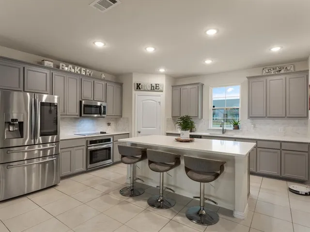 a kitchen with appliances cabinets and furniture