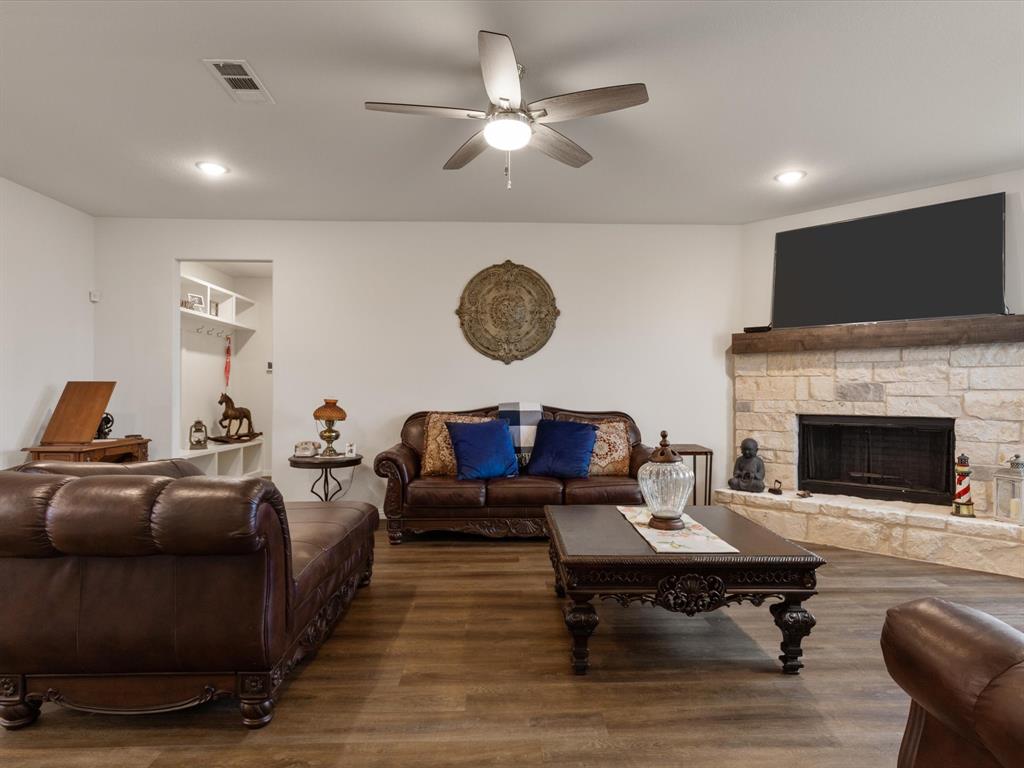 1009 Northern Oaks Court Springtown, TX 76082 - Photo 14 of 28 a living room with furniture a fireplace and a flat screen tv