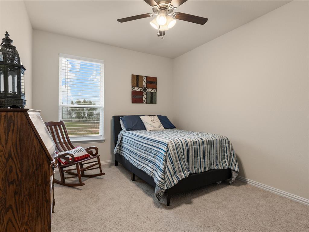 1009 Northern Oaks Court Springtown, TX 76082 - Photo 21 of 28 a bedroom with a bed and a chandelier