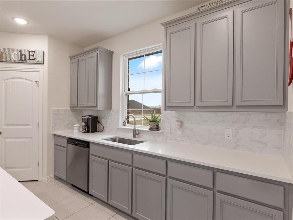 1009 Northern Oaks Court Springtown, TX 76082 - Photo 8 of 28 a kitchen with white cabinets and white appliances