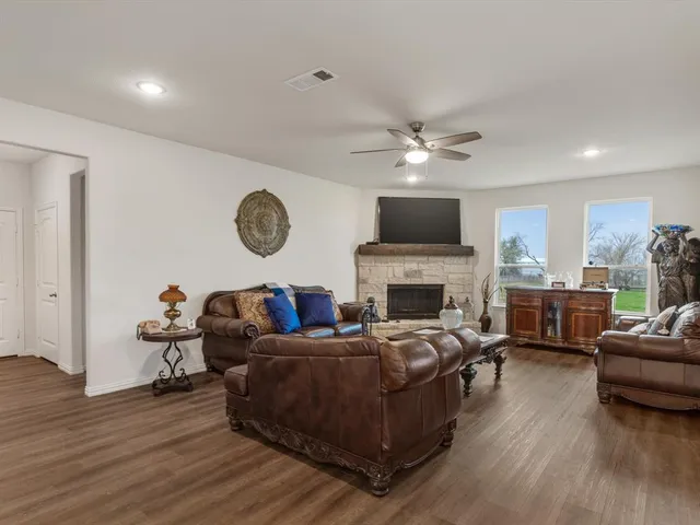 a living room with furniture a fireplace and wooden floor