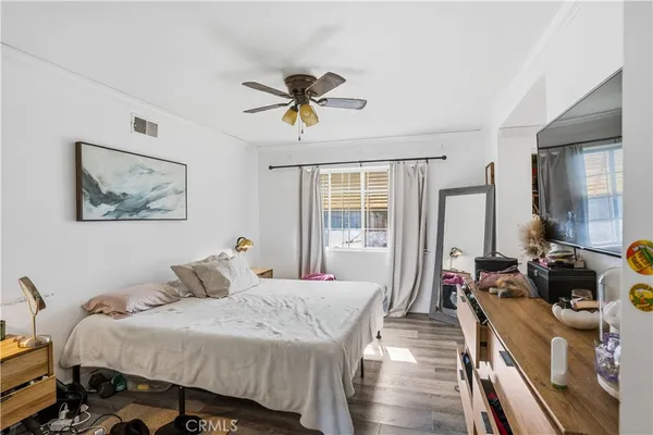 a bedroom with a bed and wooden floor