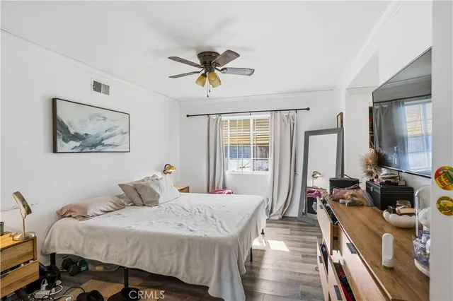 a bedroom with a bed and wooden floor