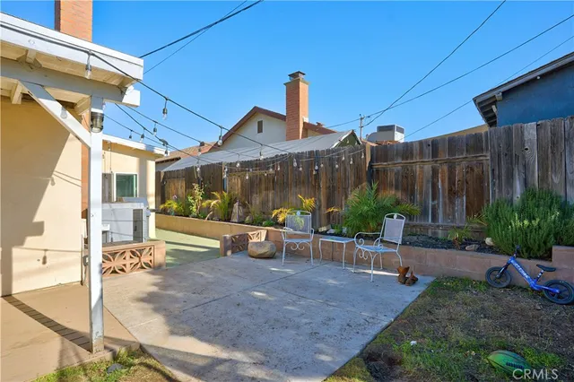a view of a patio with table and chairs potted plants with wooden fence