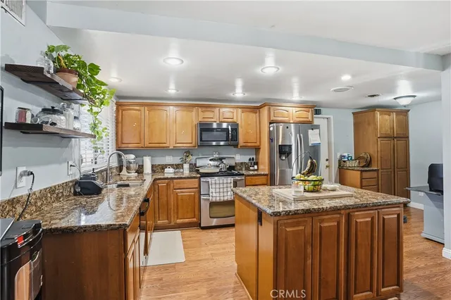 a kitchen with stainless steel appliances granite countertop a sink stove and refrigerator