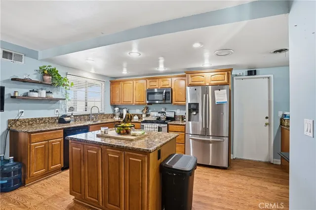 a kitchen with stainless steel appliances granite countertop a refrigerator a stove a sink dishwasher and a refrigerator