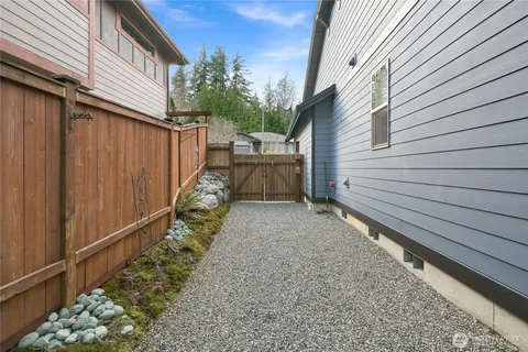 a view of backyard with wooden fence and large trees