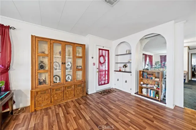 a view of an empty room with window and wooden floor