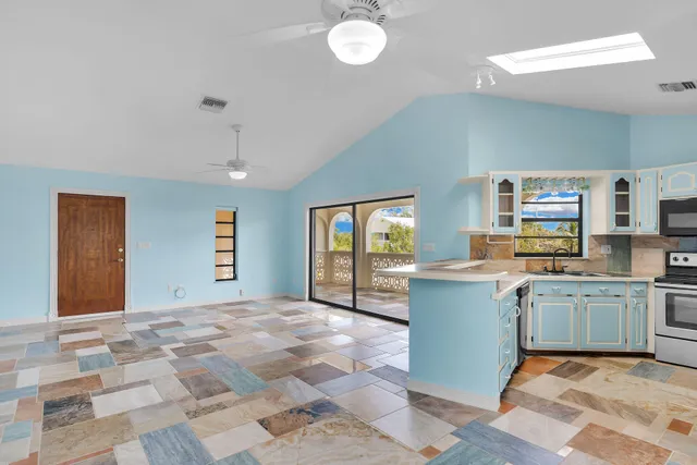 a kitchen with granite countertop a refrigerator sink and microwave