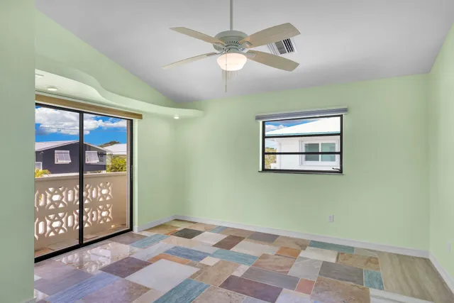 a view of a hallway with a chandelier fan and a bathroom