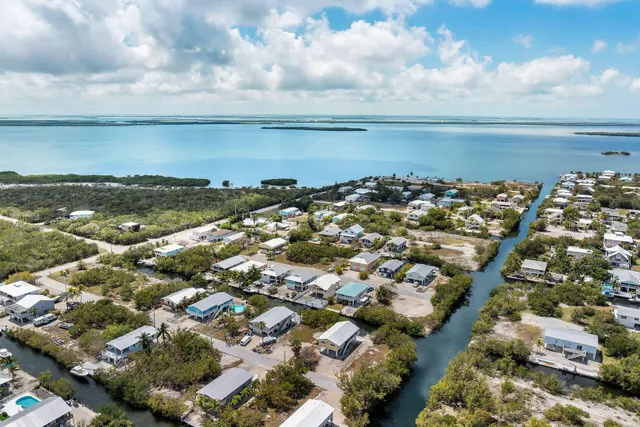 an aerial view of residential houses with outdoor space and parking