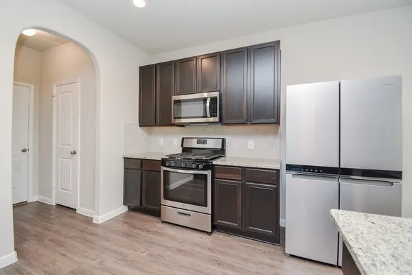 a kitchen with granite countertop wooden cabinets and stainless steel appliances