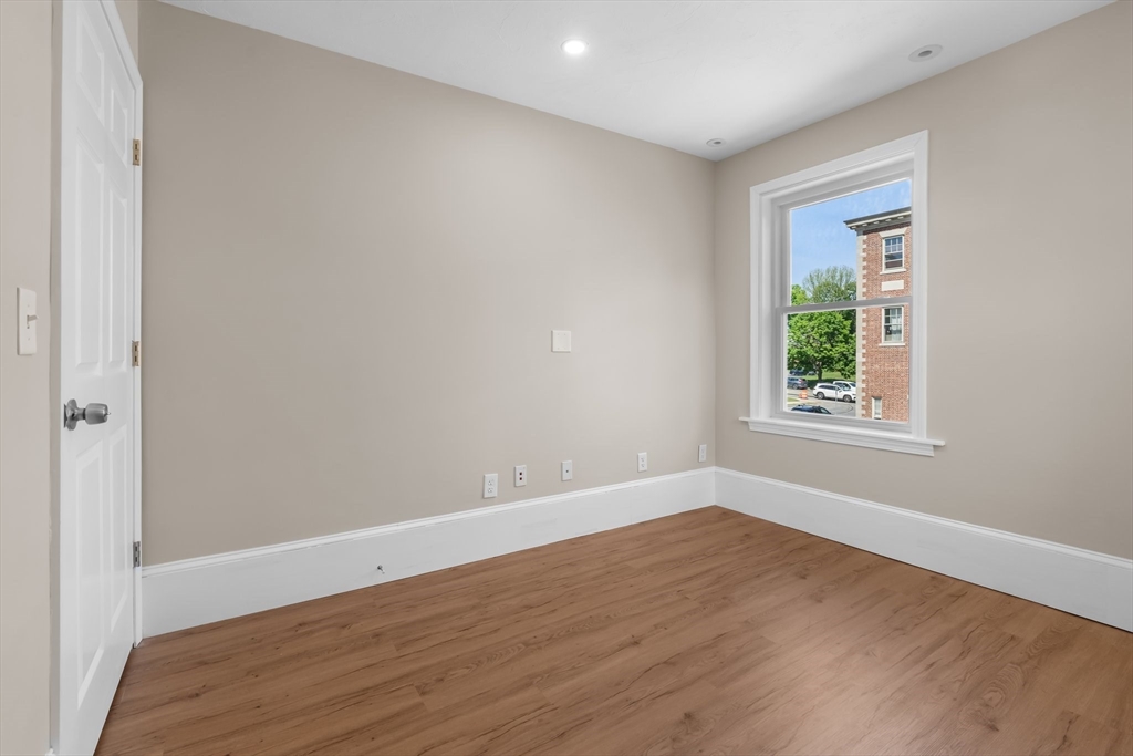 6 Windsor Street Andover, MA 01810 - Photo 14 of 34 a view of an empty room with wooden floor and a window