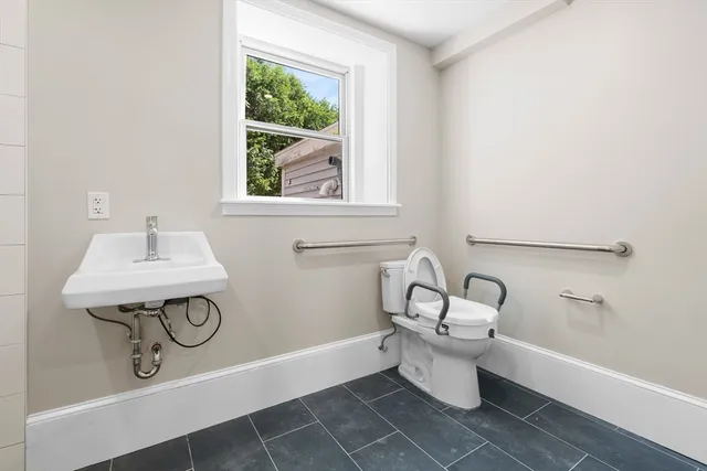 a bathroom with a sink a toilet and a window