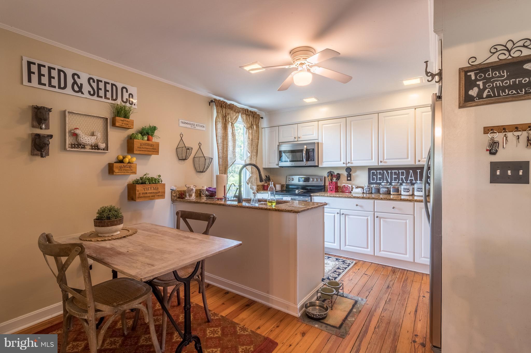170 Camp Selden Road Fredericksburg, VA 22405 - Photo 11 of 29 a kitchen with a table chairs refrigerator and microwave