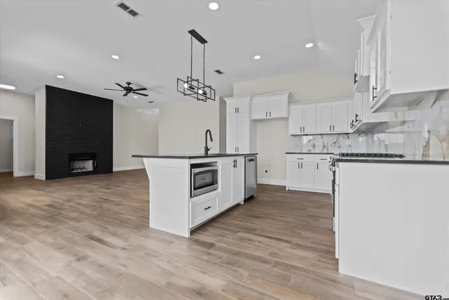 a kitchen with stainless steel appliances a refrigerator and a stove top oven