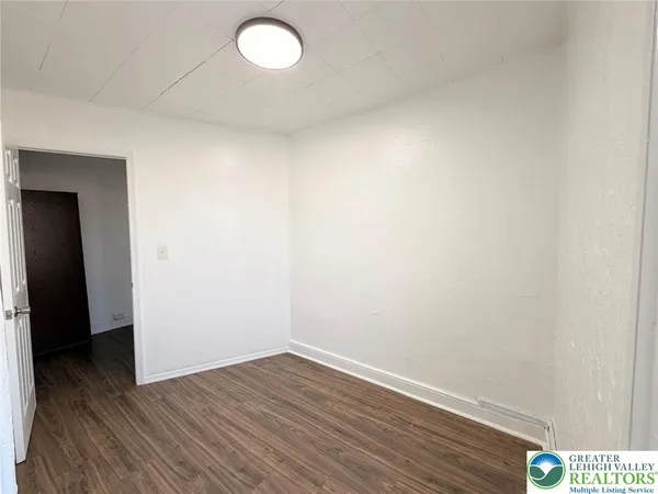 a view of an empty room and wooden floor