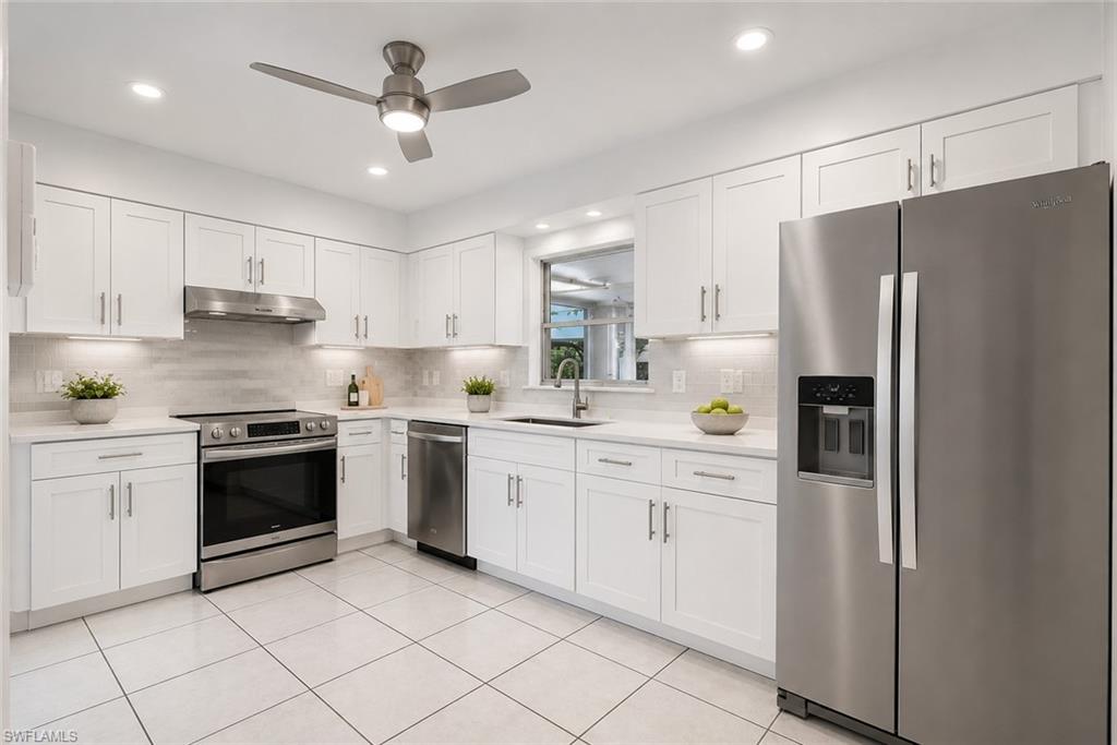 5290 Cypress Lane Naples, FL 34113 - Photo 12 of 39 a kitchen with stainless steel appliances cabinets a sink and a counter top space