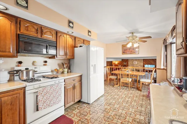 a kitchen with stainless steel appliances kitchen island granite countertop a refrigerator stove microwave and sink