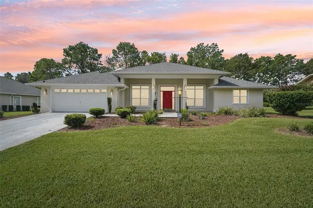 a front view of a house with a garden and yard