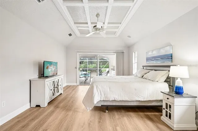 a spacious bedroom with a bed and a wooden floor