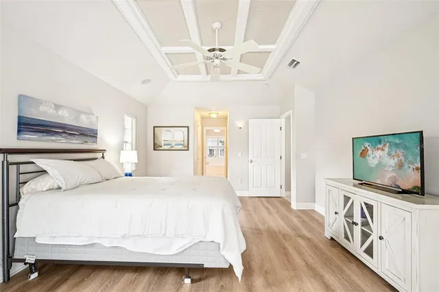 a spacious bedroom with a bed and a chandelier