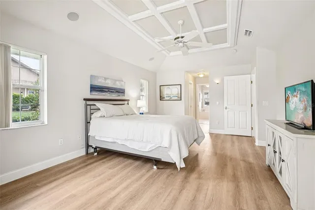 a spacious bedroom with a bed and a flat screen tv