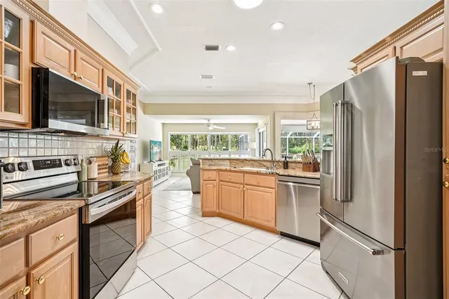 a kitchen with stainless steel appliances granite countertop a refrigerator a stove top oven and sink