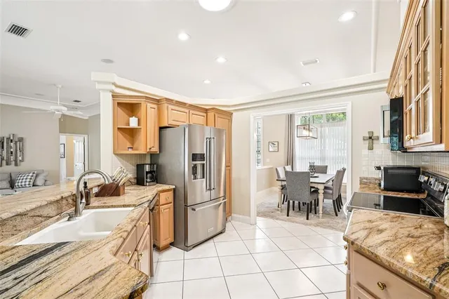 a kitchen with granite countertop a sink and chairs