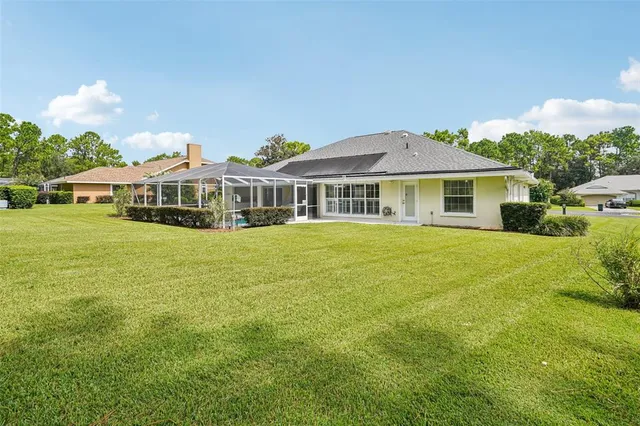 a view of a house with a big yard and large trees