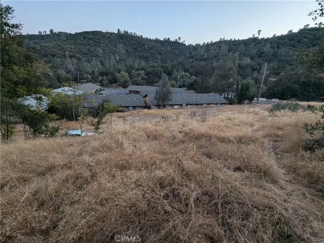 a view of a dry yard with mountains in the background