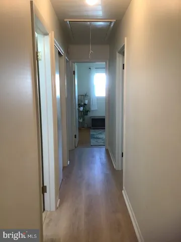 a view of a hallway with wooden floor