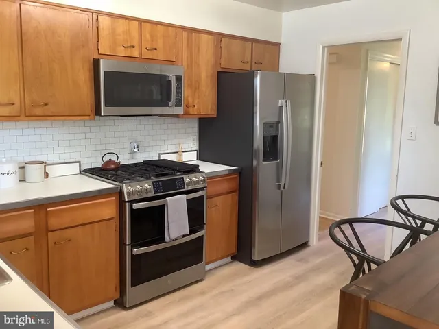 a kitchen with stainless steel appliances a stove a microwave and a sink