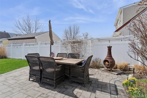 a view of a patio with table and chairs with wooden floor and fence
