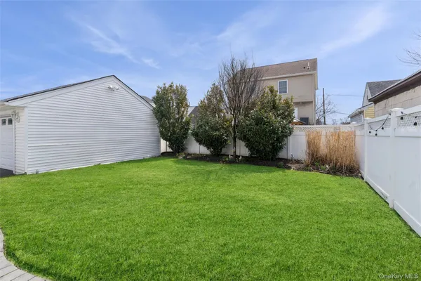 a backyard of a house with plants and wooden fence